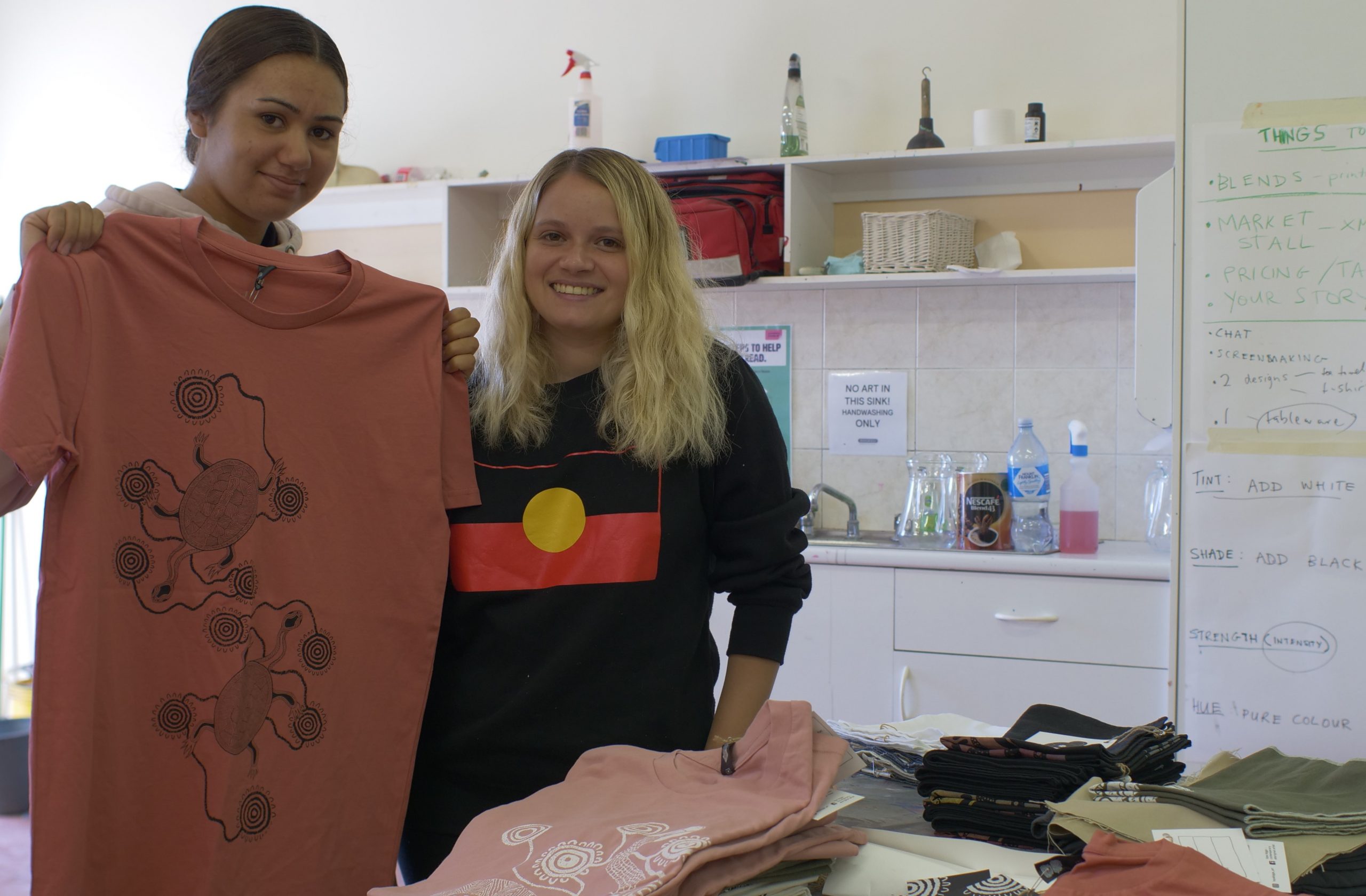 Taya Biggs (left) and Jade Cicak (Right) are part of a group that have been refining their own designs and screen printing them on products that will be for sale at today’s Fresh Water Festival for the Barka