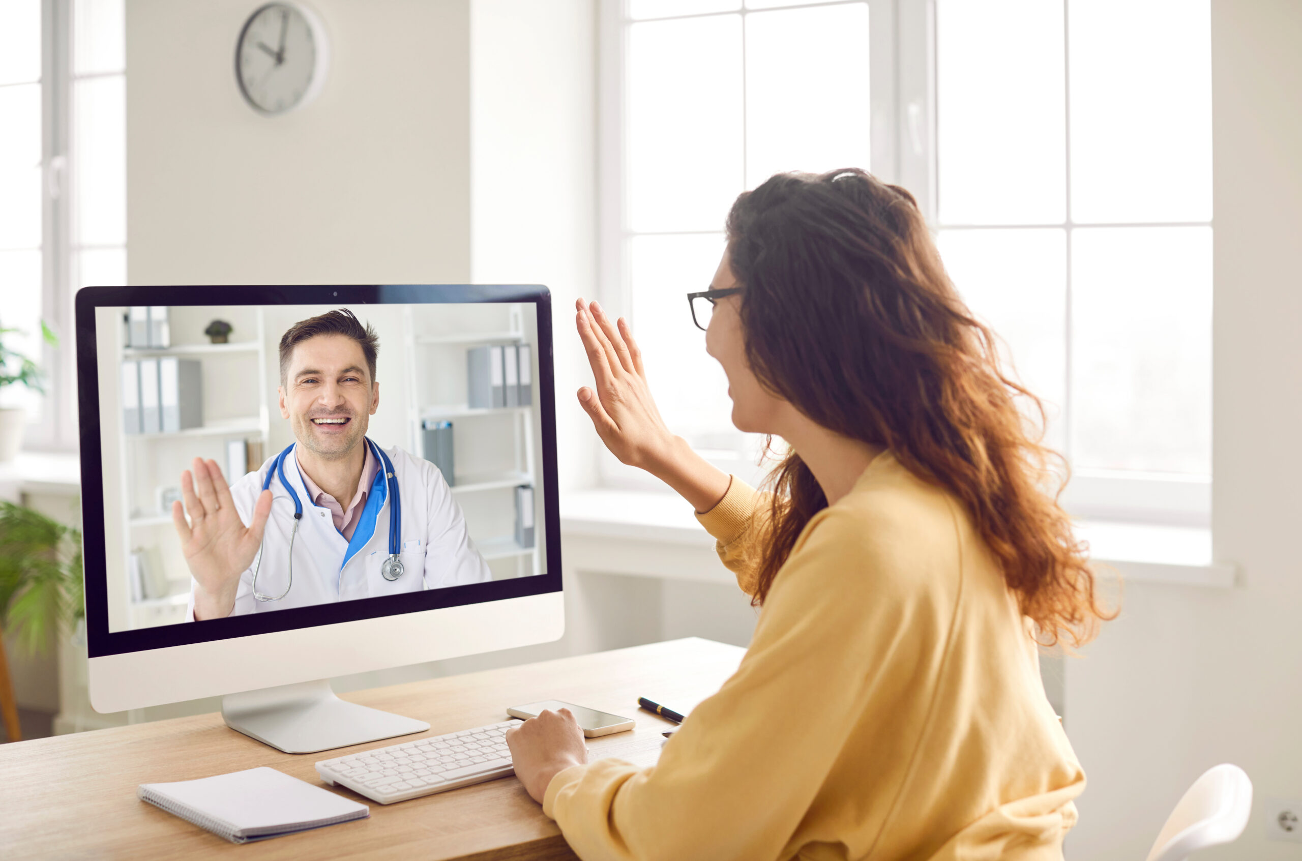 Woman says hello to online doctor when they start medical consultation via video call